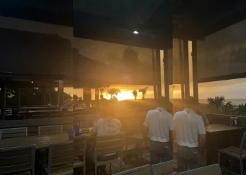Tramonto tropicale arancione con persone sulla terrazza ristorante