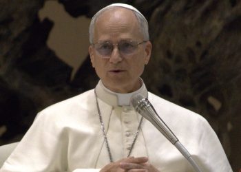 Primo piano di Papa Leone XIV durante un intervento pubblico in Vaticano, con abito bianco papale e microfono, in un’immagine legata al commissariamento dell’ospedale di Padre Pio.
