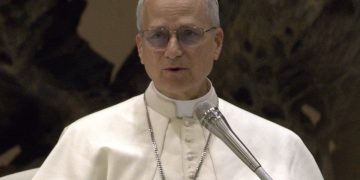 Primo piano di Papa Leone XIV durante un intervento pubblico in Vaticano, con abito bianco papale e microfono, in un’immagine legata al commissariamento dell’ospedale di Padre Pio.