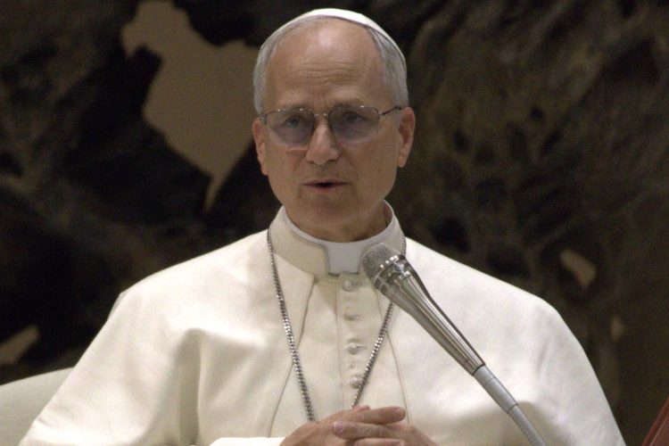 Primo piano di Papa Leone XIV durante un intervento pubblico in Vaticano, con abito bianco papale e microfono, in un’immagine legata al commissariamento dell’ospedale di Padre Pio.