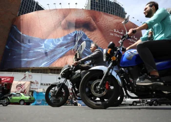 People drive near a huge anti-US billboard with photo depicting US President Donald Trump at Valiasr square in Tehran, Iran, 06 May 2026