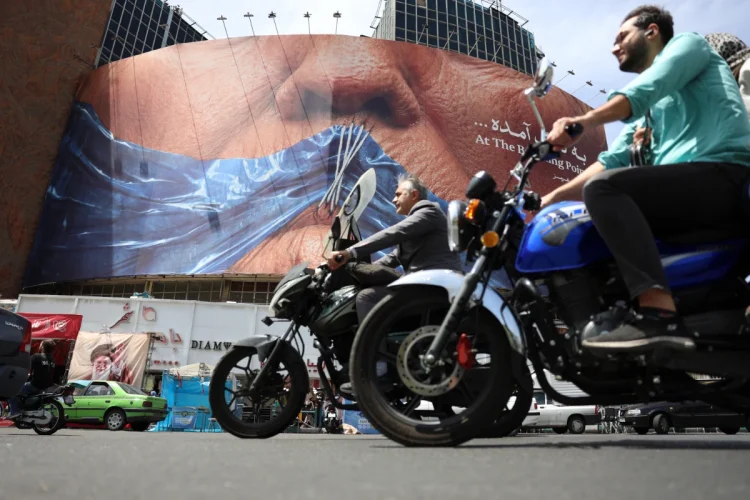 People drive near a huge anti-US billboard with photo depicting US President Donald Trump at Valiasr square in Tehran, Iran, 06 May 2026