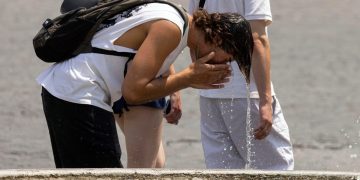 Turisti si proteggono dal caldo a Roma