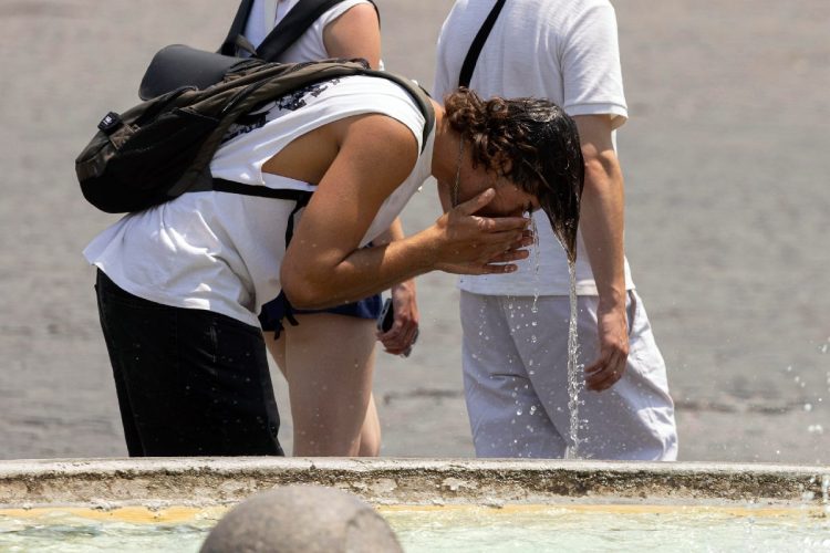 Turisti si proteggono dal caldo a Roma