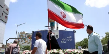 a-woman-holds-iran-s-national-flag-in-a-street-in-tehran-iran-17-may-2026-1200x800.webp
