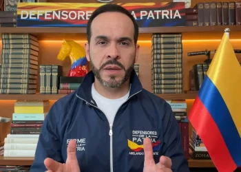 Abelardo de la Espriella parla, sullo sfondo bandiera colombiana e libri.