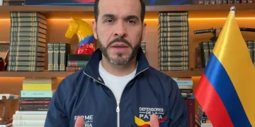 Abelardo de la Espriella parla, sullo sfondo bandiera colombiana e libri.
