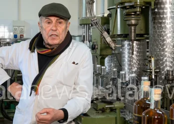 Agostino Jacobelli nel suo laboratorio con macchinari e bottiglie