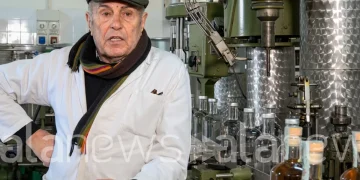 Agostino Jacobelli nel suo laboratorio con macchinari e bottiglie