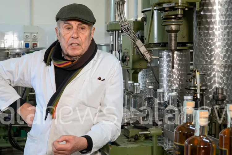 Agostino Jacobelli nel suo laboratorio con macchinari e bottiglie