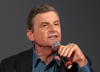 Carlo Calenda parla a un microfono durante un evento pubblico
