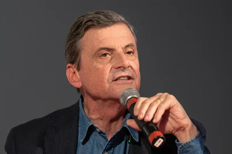 Carlo Calenda parla a un microfono durante un evento pubblico