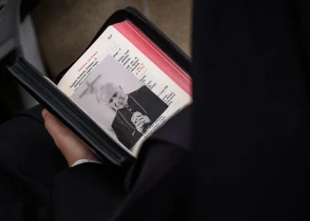 Folla tiene libro liturgico con foto dell arcivescovo Lefebvre