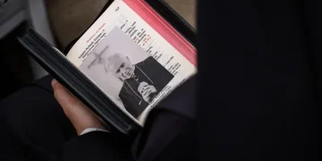 Folla tiene libro liturgico con foto dell arcivescovo Lefebvre