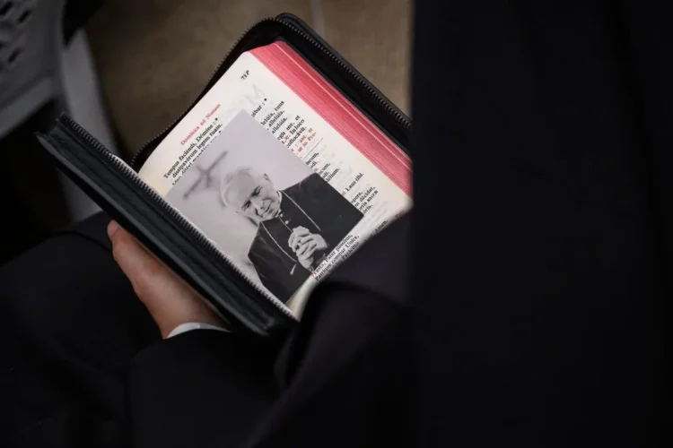 Folla tiene libro liturgico con foto dell arcivescovo Lefebvre