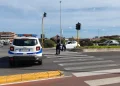 Agenti polizia locale regolano traffico, veicolo di pattuglia sullo sfondo