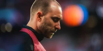 Christian Eriksen pensieroso in campo con pettorina da allenamento