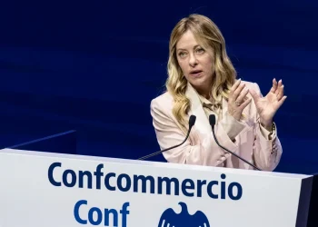 Giorgia Meloni parla al convegno Confcommercio con microfoni.