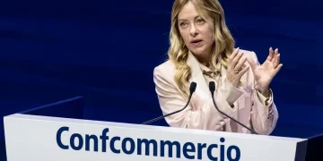 Giorgia Meloni parla al convegno Confcommercio con microfoni.
