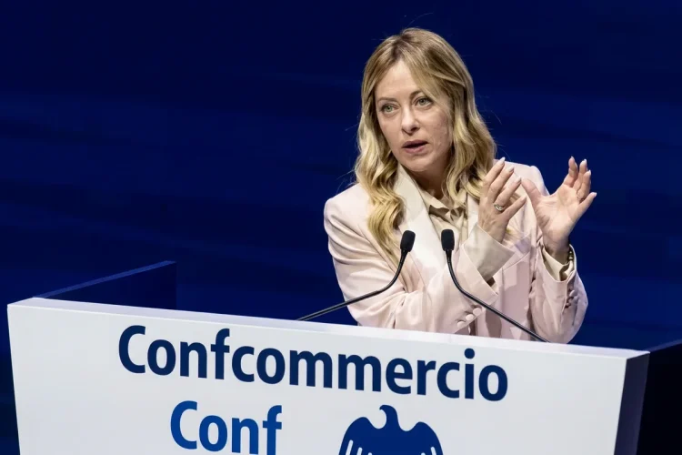 Giorgia Meloni parla al convegno Confcommercio con microfoni.
