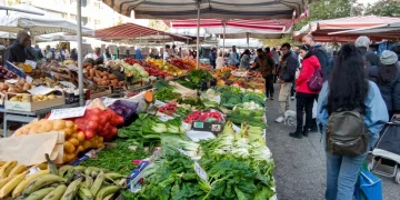 Bancarelle del mercato con frutta e verdura fresca e acquirenti