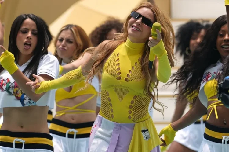 Shakira canta occhiali da sole sul palco con vestito giallo
