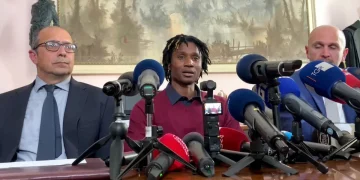 Dassilva parla, circondato da microfoni alla conferenza stampa, dopo l'assoluzione per l'omicidio di Pierina Paganelli