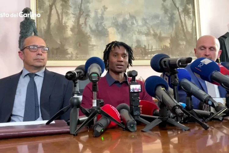 Dassilva parla, circondato da microfoni alla conferenza stampa, dopo l'assoluzione per l'omicidio di Pierina Paganelli