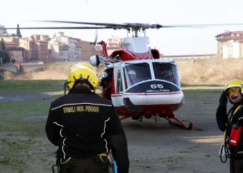 Vigili del Fuoco accanto elicottero in campo durante operazioni ricerca