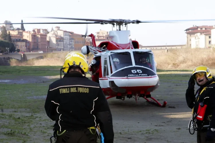 Vigili del Fuoco accanto elicottero in campo durante operazioni ricerca