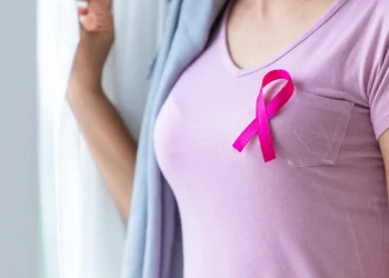 Donna con nastro rosa sulla maglietta, simbolo cancro al seno