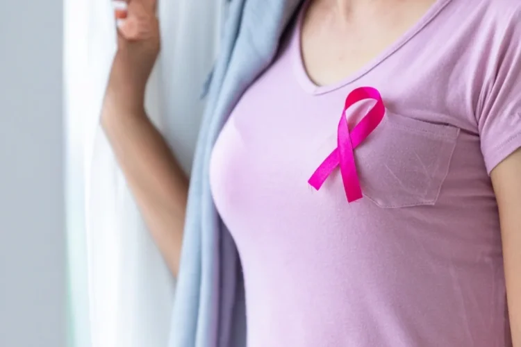 Donna con nastro rosa sulla maglietta, simbolo cancro al seno