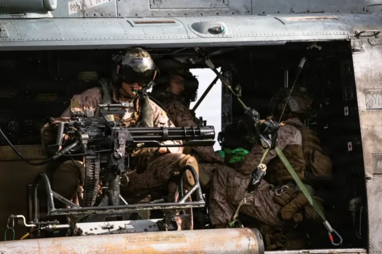 Marines con mitragliatrice a bordo di un elicottero militare