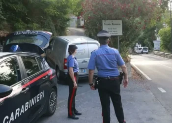Carabinieri presidiano una strada boschiva a Ceriana, vicino a un furgone bianco.