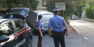 Carabinieri presidiano una strada boschiva a Ceriana, vicino a un furgone bianco.