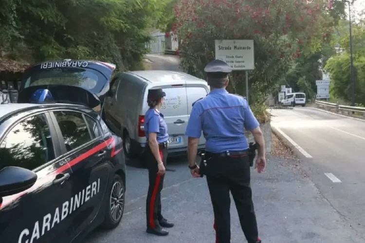 Carabinieri presidiano una strada boschiva a Ceriana, vicino a un furgone bianco.