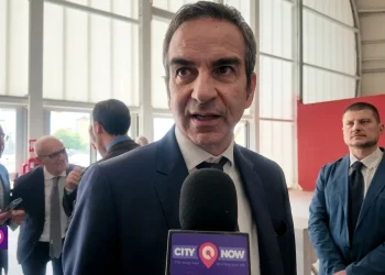 Uomo in giacca e cravatta parla al microfono "CITYNOW"
