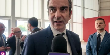 Uomo in giacca e cravatta parla al microfono "CITYNOW"