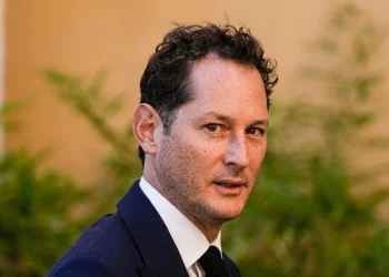 John Elkann volge lo sguardo di tre quarti in primo piano.