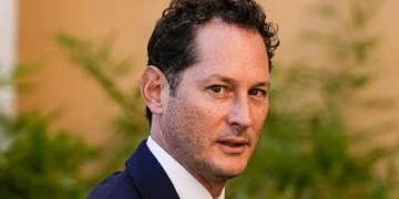 John Elkann volge lo sguardo di tre quarti in primo piano.