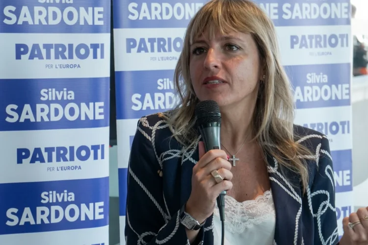 Silvia Sardone parla al microfono, sfondo banner elettorale del partito Patrioti.