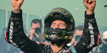 Fabio Quartararo alza le braccia, festeggiando la vittoria sul podio.