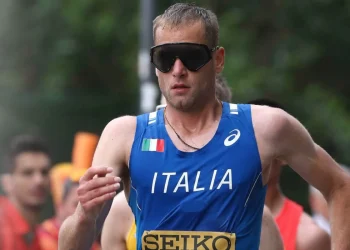 Atleta italiano con maglia blu Italia e occhiali neri sportivi