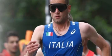 Atleta italiano con maglia blu Italia e occhiali neri sportivi