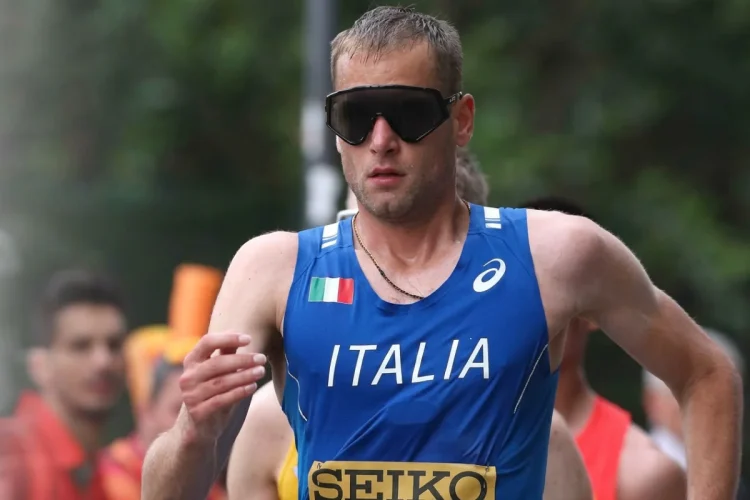 Atleta italiano con maglia blu Italia e occhiali neri sportivi