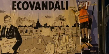 Attivisti coprono cartellone Leonardo con scritta ECOVANDALI a Torino.