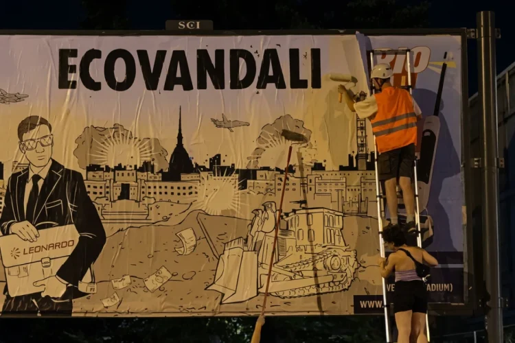 Attivisti coprono cartellone Leonardo con scritta ECOVANDALI a Torino.