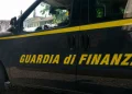 Furgone scuro della Guardia di Finanza con strisce gialle