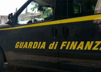 Furgone scuro della Guardia di Finanza con strisce gialle