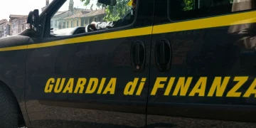Furgone scuro della Guardia di Finanza con strisce gialle